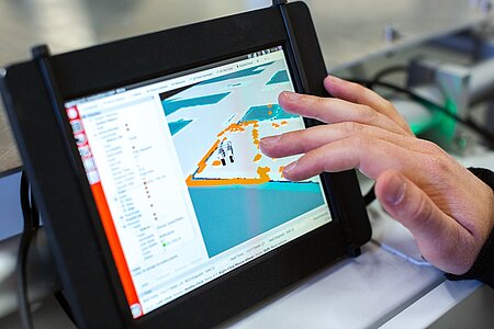 Engineer interacteert met 3D-ontwerp op touchscreen in technische omgeving